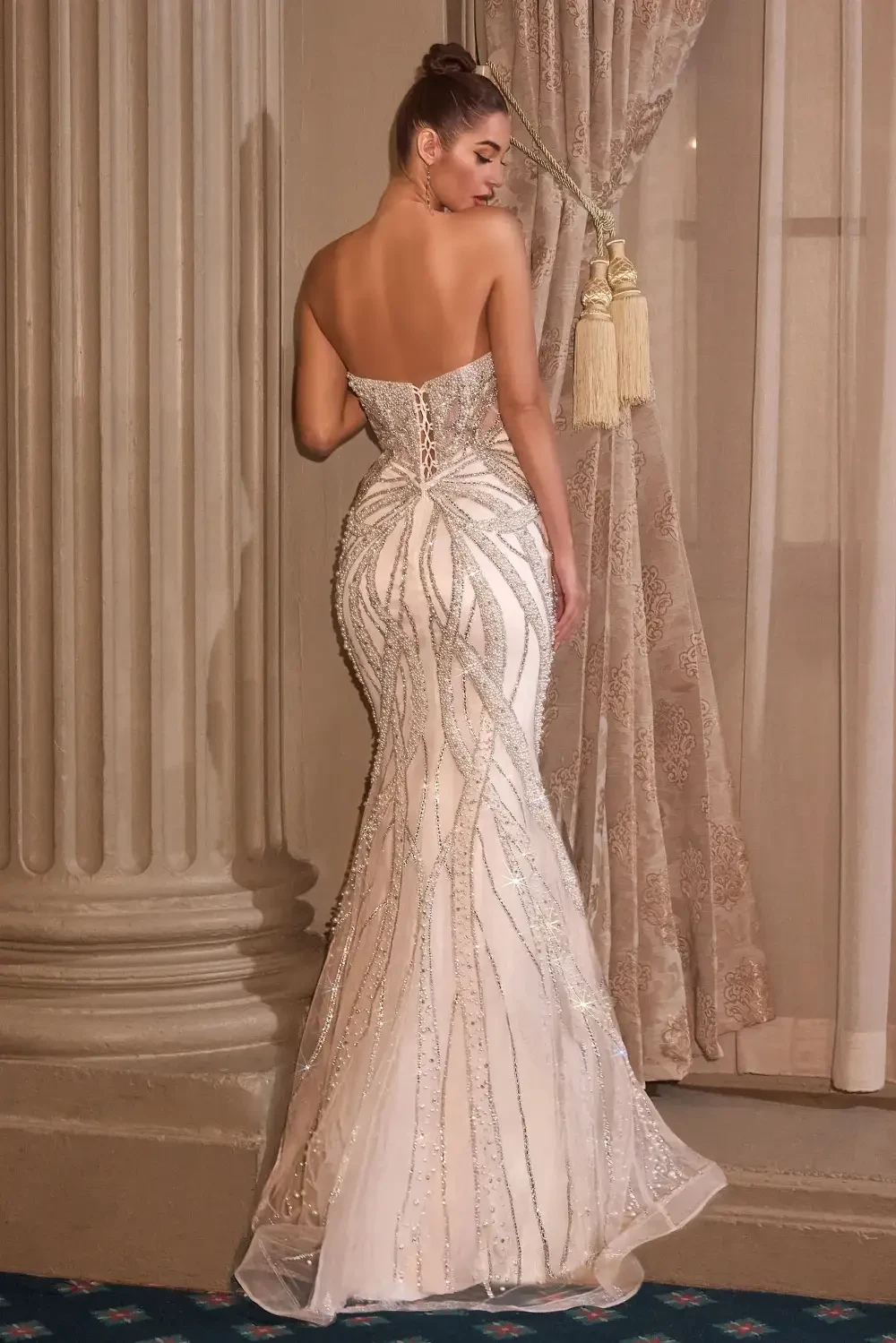 model is wearing a sleeveless open back bridal gown