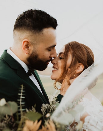 Сouple wearing a white gown and a black suit