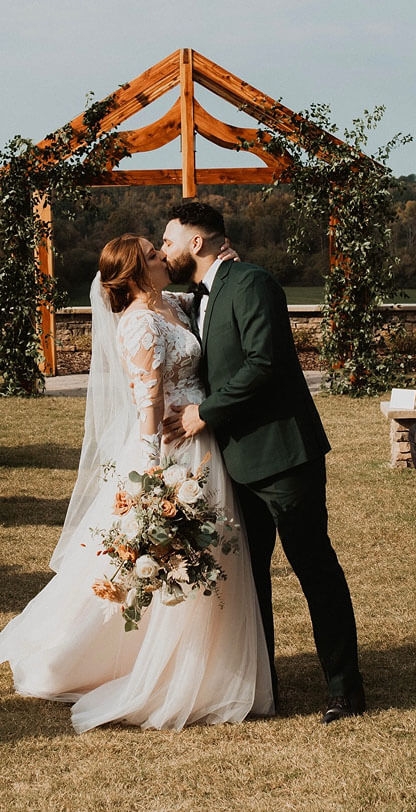 Сouple wearing a white gown and a black suit on the field